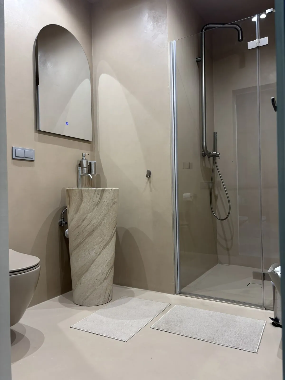 Lietus duša un travertīna izlietne mikrocementā — Kaia House, Ventspils